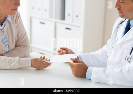 Frau und Arzt mit Rezept in Klinik Stockfoto