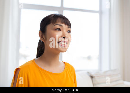 Portrait von lächelnden jungen asiatischen Frau zu Hause Stockfoto