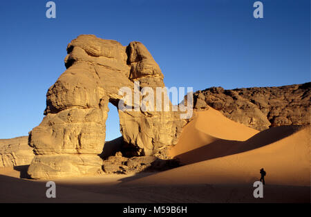 Libyen. In der Nähe von Ghat. Sahara. Akakus (acacus) National Park. Natural Arch Fezzenger genannt. Touristische, Frau. Stockfoto