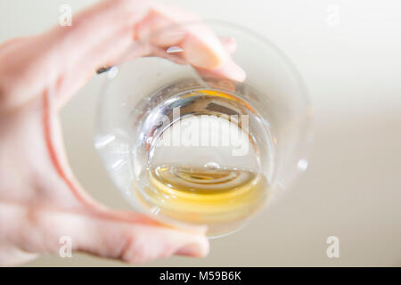 Hand mit einem kleinen Maß Scotch in einem Kristall Glas. Stockfoto