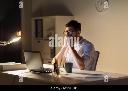 Müde Geschäftsmann mit Laptop in der Nacht Büro Stockfoto