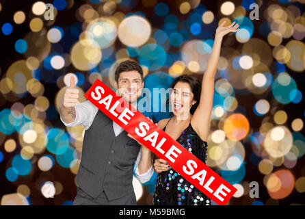 Glückliches Paar mit roten Verkauf Zeichen zeigen Daumen hoch Stockfoto