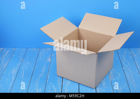 Porto und Verpackung service-Paket öffnen auf blauem Holz Hintergrund. Stockfoto