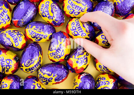 Eine Hand griff nach einem Cadbury Creme Egg Stockfoto