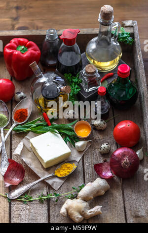 Verschiedene Gewürze, Öle und Saucen Auswahl auf Holz- Hintergrund. Stockfoto