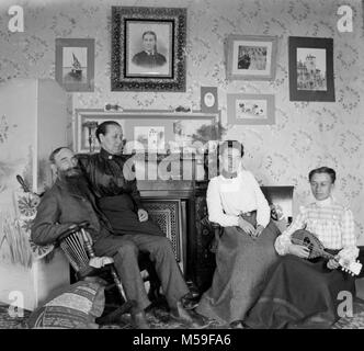 Mandoline Musik ist im Wohnzimmer für die erweiterte Familie durchgeführt, Ca. 1900. Stockfoto