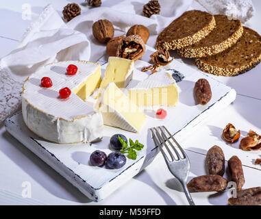 Runde Camembert Käse, Scheiben geräucherter Wurst und Brot aus Roggen Mehl auf ein weißes Holzbrett, weiß Holz- Tabelle, Ansicht von oben Stockfoto