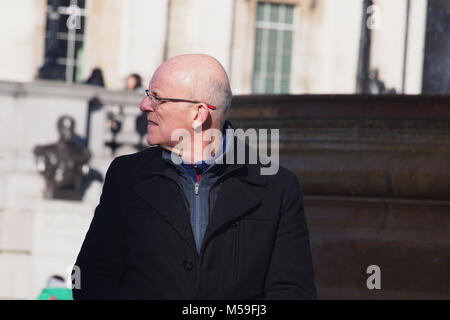 Eine ältere, glatzköpfige Mann, seitwärts auf etwas, das sein Auge im Winter Sonne verfangen hat, suchen, Trafalgar Square London Stockfoto