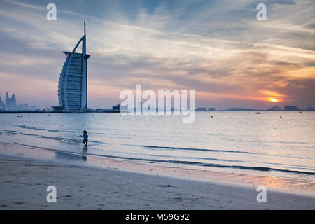 DUBAI, VAE - Februar 2018: Der weltweit erste 7-Sterne Luxushotel Burj Al Arab bei Sonnenuntergang von öffentlichen Strand Jumeirah in Dubai, Vereinigte Arabische Em gesehen Stockfoto