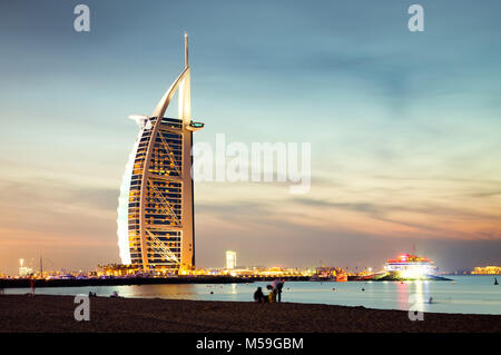 DUBAI, VAE - Februar 2018: Der weltweit erste 7-Sterne Luxushotel Burj Al Arab bei Nacht vom Jumeirah Strand in Dubai, Vereinigte Arabische Emi gesehen Stockfoto