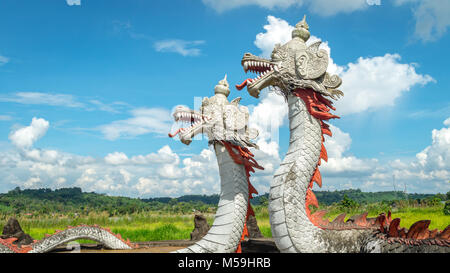 Statue von Twin Dragon, mythologische Kreaturen von kutai Stamm, mit schönen Wolkenbildung und grüne Landschaft als Hintergrund, in Pulau Kumala, Stockfoto