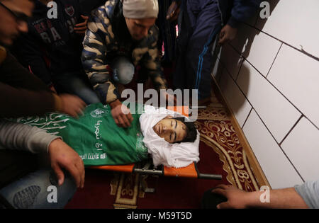 Rafah, Gaza, palästinensischen Gebiet. 21 Feb, 2018. Palästinenser sammeln über den Körper von Ahmed Ebu Helou, 19, der an seinen Verletzungen starb, nachdem israelische Sicherheitskräfte schossen ihn bei Auseinandersetzungen gegen die Entscheidung der US-Jerusalem als Hauptstadt Israels zu erkennen, während seiner Beerdigung, in al-bureij Flüchtlingslager, in der Mitte des Gazastreifens am 21 Februar, 2018 Credit: Ashraf Amra/APA-Images/ZUMA Draht/Alamy leben Nachrichten Stockfoto