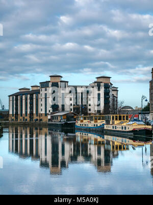 Sonnenschein auf Leith, Wasser des Leith Fluss, Leith, Edinburgh, Schottland, Vereinigtes Königreich, 21. Februar 2018. UK Wetter. Sehr schönes, helles, sonniges Wetter, blauer Himmel und ruhiges Wasser schafft bunte Reflexionen eines modernen Mehrfamilienhaus in der Oberfläche des Wassers am Flussufer Stockfoto