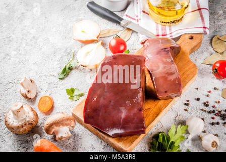 Rohes Rindfleisch Leber mit Gewürzen, Kräutern und Gemüse, grauen Stein Tabelle kopieren Raum Stockfoto