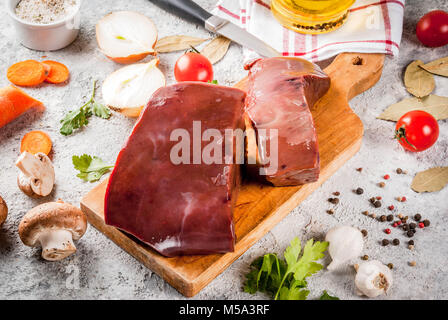 Rohes Rindfleisch Leber mit Gewürzen, Kräutern und Gemüse, grauen Stein Tabelle kopieren Raum Stockfoto