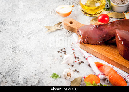 Rohes Rindfleisch Leber mit Gewürzen, Kräutern und Gemüse, grauen Stein Tabelle kopieren Raum Stockfoto