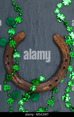 Lucky horse shoe mit St Patrick's Day green clover Dekorationen Stockfoto