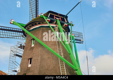 Mann auf Leiter dekorieren Windmühle, Zaanse Schans, einem Dorf in der Nähe von zaandijk in der Gemeinde Zaanstad, Nord Holland, Niederlande. Stockfoto