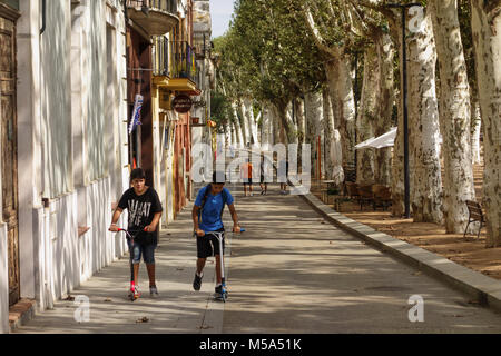 Menschen zu Fuß entlang der mit Bäumen gesäumten Avenue Passeig Marimon Asprer' auf dem Ufer des Riu Daro in La Bisbal d'Emporda, Baix Emporda, Katalonien, Spai Stockfoto