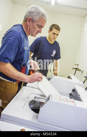 Miami Beach Florida, Presidential Wohnanlagen, Waschküche, Feuerwehrmann, Feuerwehrmann, inspiziert Trockner, elektrische Fehlfunktion, Feuer, Sicherheit, Besucher reisen Stockfoto