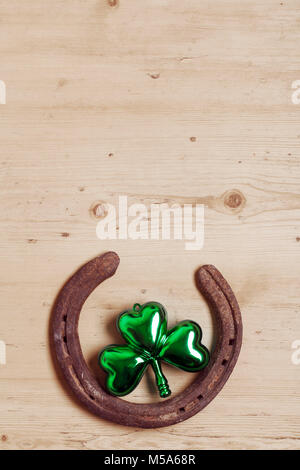 Lucky horse shoe mit St Patrick's Day green clover Dekorationen Stockfoto