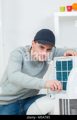 gut aussehend Techniker Installation Klimaanlage im Gebäude Stockfoto