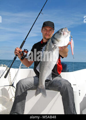 Lucky Fisherman Holding eine große Seebarsch Stockfoto