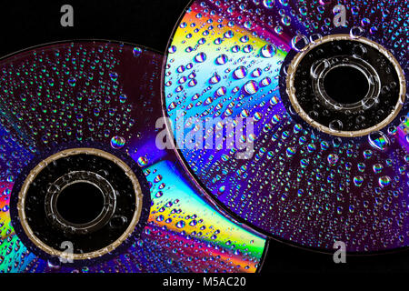Ein paar CD's für einige "leichte" Musik. Wassertropfen und buntes Licht Spektrum auf dem glänzenden Oberflächen der Scheiben reflektiert Stockfoto
