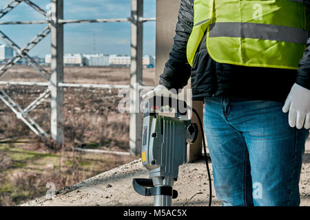 Mann mit einem Presslufthammer auf der Baustelle Stockfoto