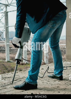 Mann mit einem Presslufthammer auf der Baustelle Stockfoto