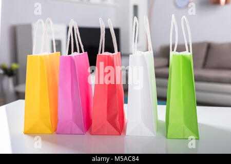 In der Nähe der Bunten Einkaufstaschen auf weißem Schreibtisch Stockfoto