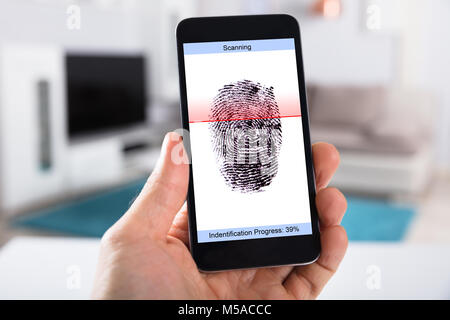 Person's Hand mit Handy Übersicht Scannen der Fingerabdruck auf einem Bildschirm Stockfoto