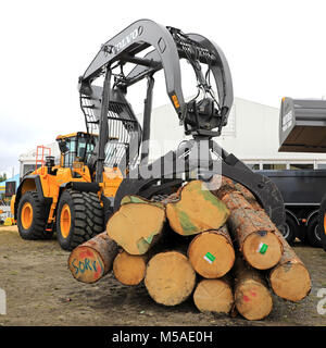 HYVINKAA, Finnland - 8 September, 2017: Volvo Radlader mit großen Greifer voll von Schnittholz Rundholz. Stockfoto