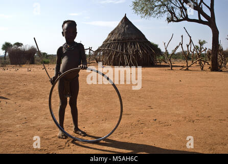 Mädchen spielen mit einer Felge (Äthiopien). Sie gehört zu den Hamer Stamm. Stockfoto