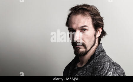 Porträt einer stattlichen ernste und beiläufige junge Menschen gegen den grauen Hintergrund. Stockfoto