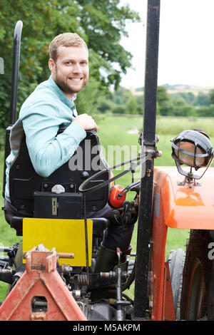 Porträt des Bauern sitzen auf Traktor im Feld Stockfoto