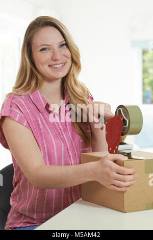 Portrait von Frau zu Hause Abdichtung Box für den Versand Stockfoto