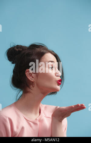 Portrait von attraktiven nettes Mädchen mit hellen Make-up mit kiss über blau Hintergrund isoliert Stockfoto