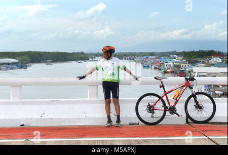 RAYONG, THAILAND - Jun 25: Unbekanntes alter Mann und sein Fahrrad entspannend nach lange Radtouren im Sonnenuntergang am Juni 25,2016 in Rayong, Thailand. Stockfoto
