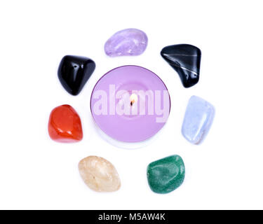 Lavendel tee Kerze durch sieben Heilung chakra Steine für Crystal Healing, auf weißem Hintergrund umgeben Stockfoto