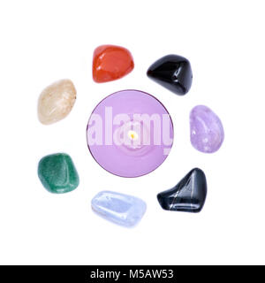 Lavendel tee Kerze durch sieben Heilung chakra Steine für Crystal Healing, auf weißem Hintergrund umgeben Stockfoto