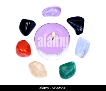 Lavendel tee Kerze durch sieben Heilung chakra Steine für Crystal Healing, auf weißem Hintergrund umgeben Stockfoto