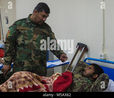 Sgt. Maj. Waheddin Wafa, command Sergeant Major der afghanischen Armee (ANA) 215 Corps, Besuche mit verwundeten Soldaten der ANA 215 Corps Camp Shorabak, Afghanistan, 8. Februar, 2018. Wafa persönlich besucht jeder Soldat am Krankenhaus und der verwundete Übergang (WTU). Die wtu bietet medizinische Hilfe für Soldaten der Wiederherstellung nach Verletzungen und bereitet sie für den Übergang zurück in den aktiven Dienst oder für eine medizinische Entlastung. (U.S. Marine Corps Stockfoto