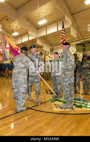 Oberst Frank Davis II, Kommandeur der 71st Ordnance Gruppe (Explosive Ordnance Disposal), Hände Command Sgt. Maj. Johnny Strickland, eingehende command Sergeant Major der 71St EOD, Farben der Einheit während eines Verantwortung Zeremonie, Feb 9, 2018, an der William Reed Special Events Center, Fort Carson, Colo (U.S. Armee Stockfoto