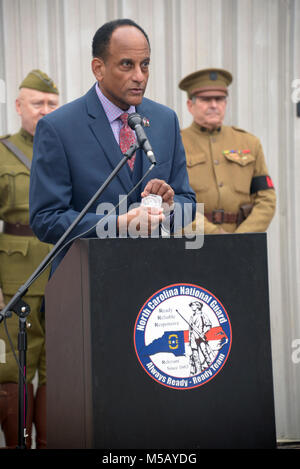 Larry Hall, Sekretär für die North Carolina Abteilung Militär & Veterans Affairs stellen eine staatliche Münze während der Spatenstich für die North Carolina National Guard Museum und das Learning Center of Excellence an der gemeinsamen Kraft Hauptsitz in Raleigh, North Carolina, 13. Februar 2018. Lokalen, staatlichen und North Carolina National Guard Führer sind anwesend für einen spatenstich an der gemeinsamen Kraft von North Carolina National Guard Hauptsitz der Beginn des Baus für die North Carolina National Guard Museum und das Learning Center of Excellence zu feiern. (U.S. Armee Stockfoto