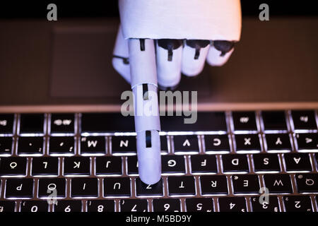 In der Nähe von einem Roboter Hand Tippen auf Laptop Stockfoto