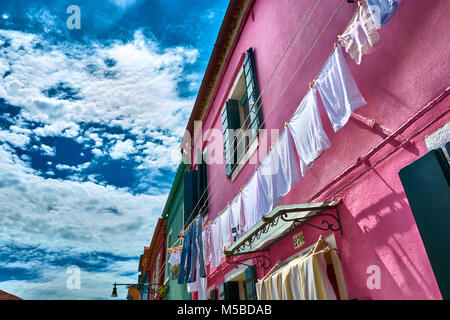 BURANO, Italien, 21. MAI 2017: Kleidung hängen an der Fassade eines Gebäudes in Burano, Italien. Stockfoto