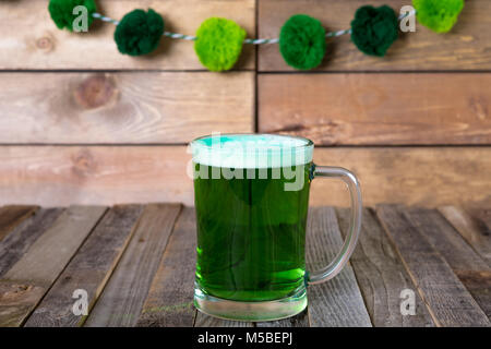 St. Patrick's Becher grün Bier auf Holz- Hintergrund. Tischplatte, Vorderansicht. Stockfoto