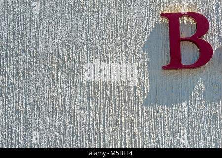 Red Letter B auf weißem Stuck Wand Stockfoto