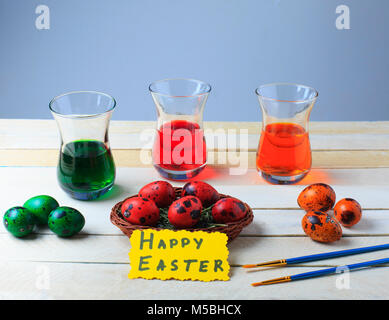 Wachteleier in den Prozess der Ausarbeitung mit bunten Essen Farbe rot, grün und orange. Ostern Konzept. Frohe Ostern. Stockfoto